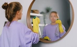 mulher limpando espelho de parede mulher limpando espelho de parede